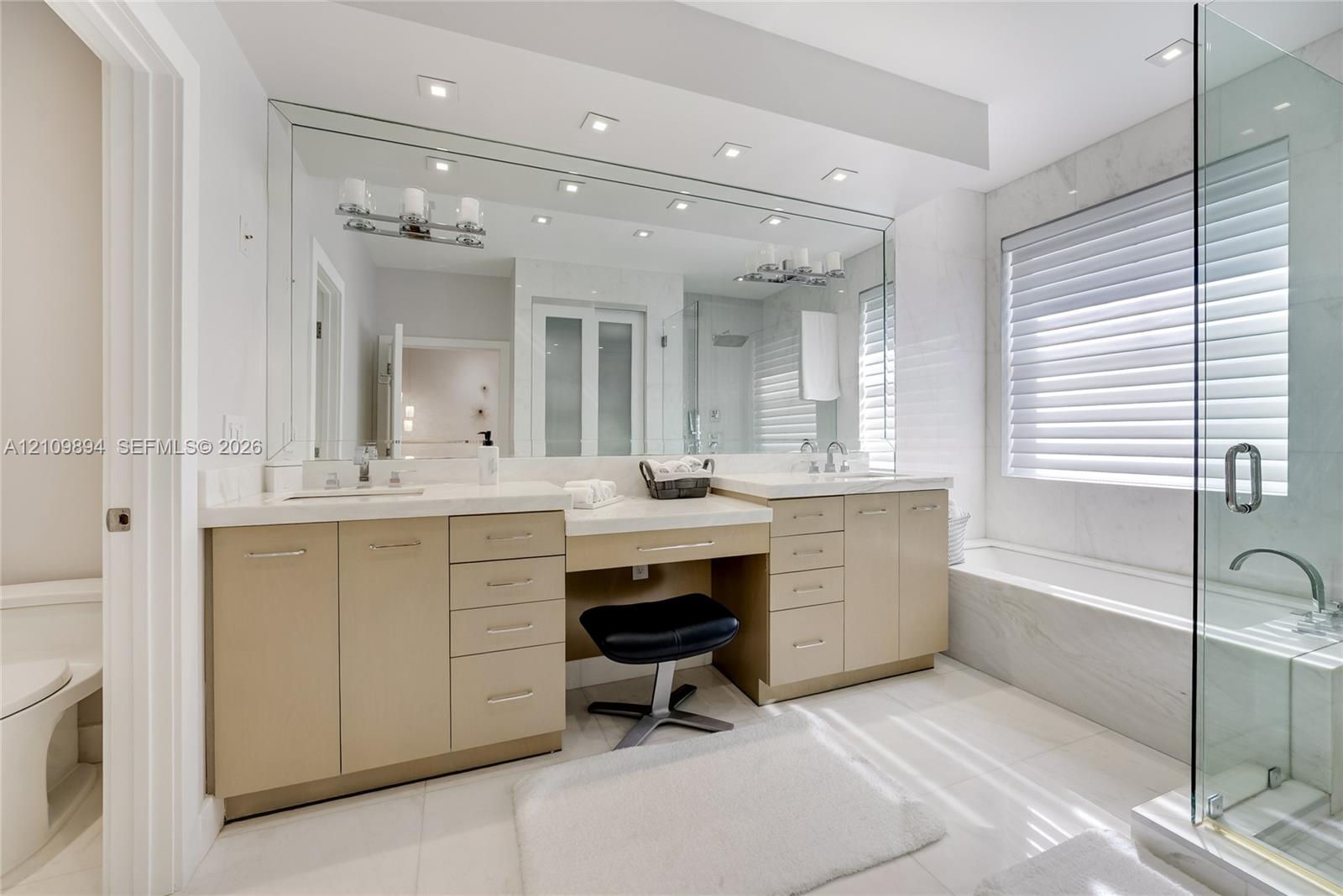 Interior space featuring recessed lighting, a built-in media console with linear fireplace, and a staircase with glass panel railing and dark finish handrail
