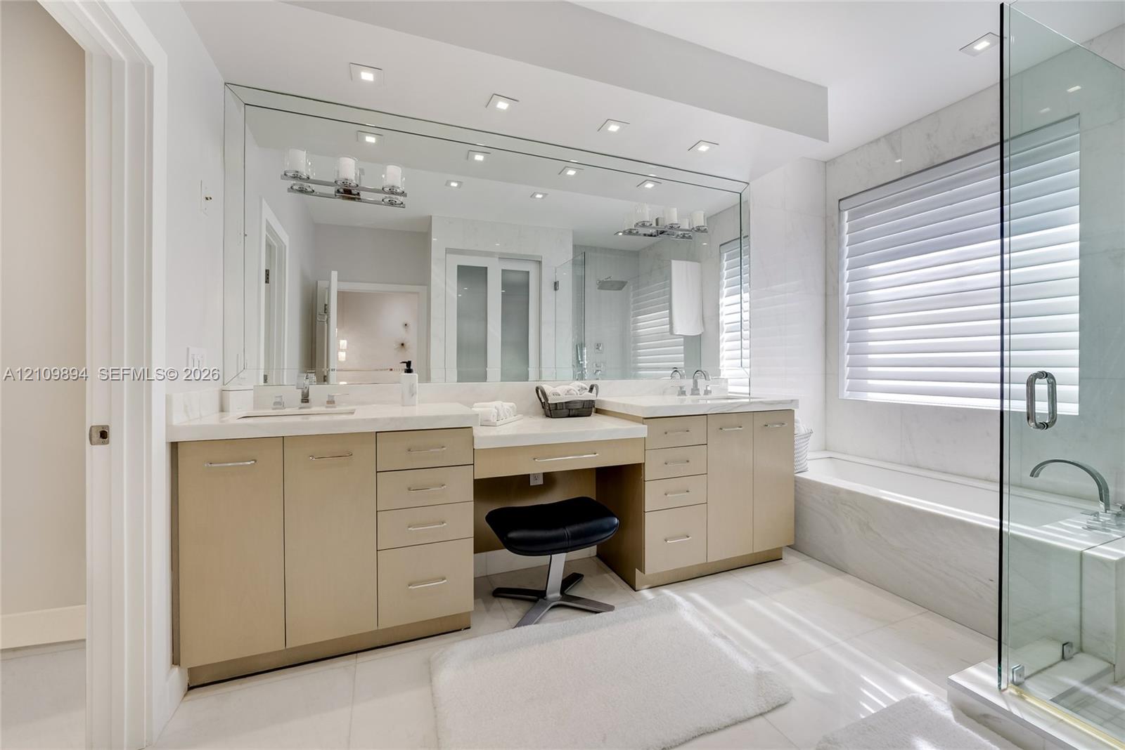 Tray ceiling featuring recessed lighting and a central decorative pendant, accompanied by wood-finish flooring and modern multi-light wall fixtures