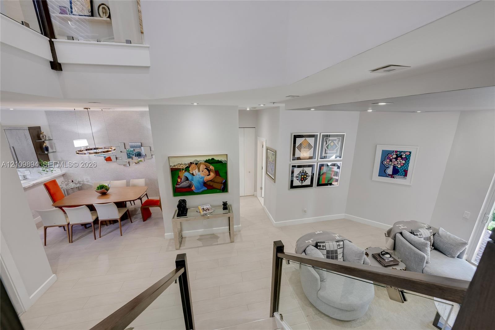 Room featuring wood-finish flooring, recessed lighting, a modern pendant light fixture, and floor-to-ceiling mirrored closet doors