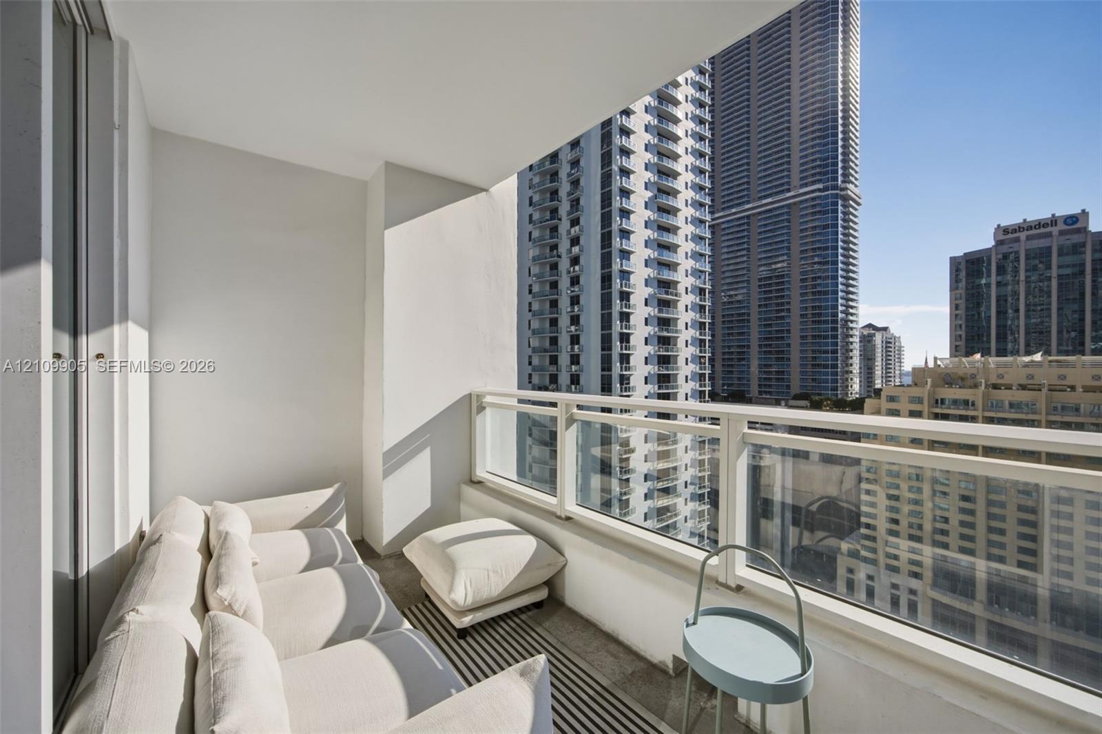 Private balcony featuring concrete flooring and glass panel railings