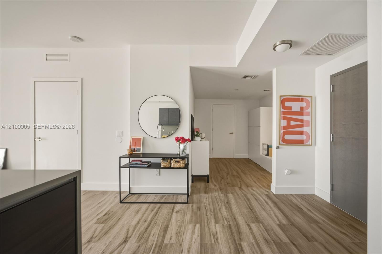 Interior space featuring wood-finish flooring, crisp white walls, and a recessed ceiling light