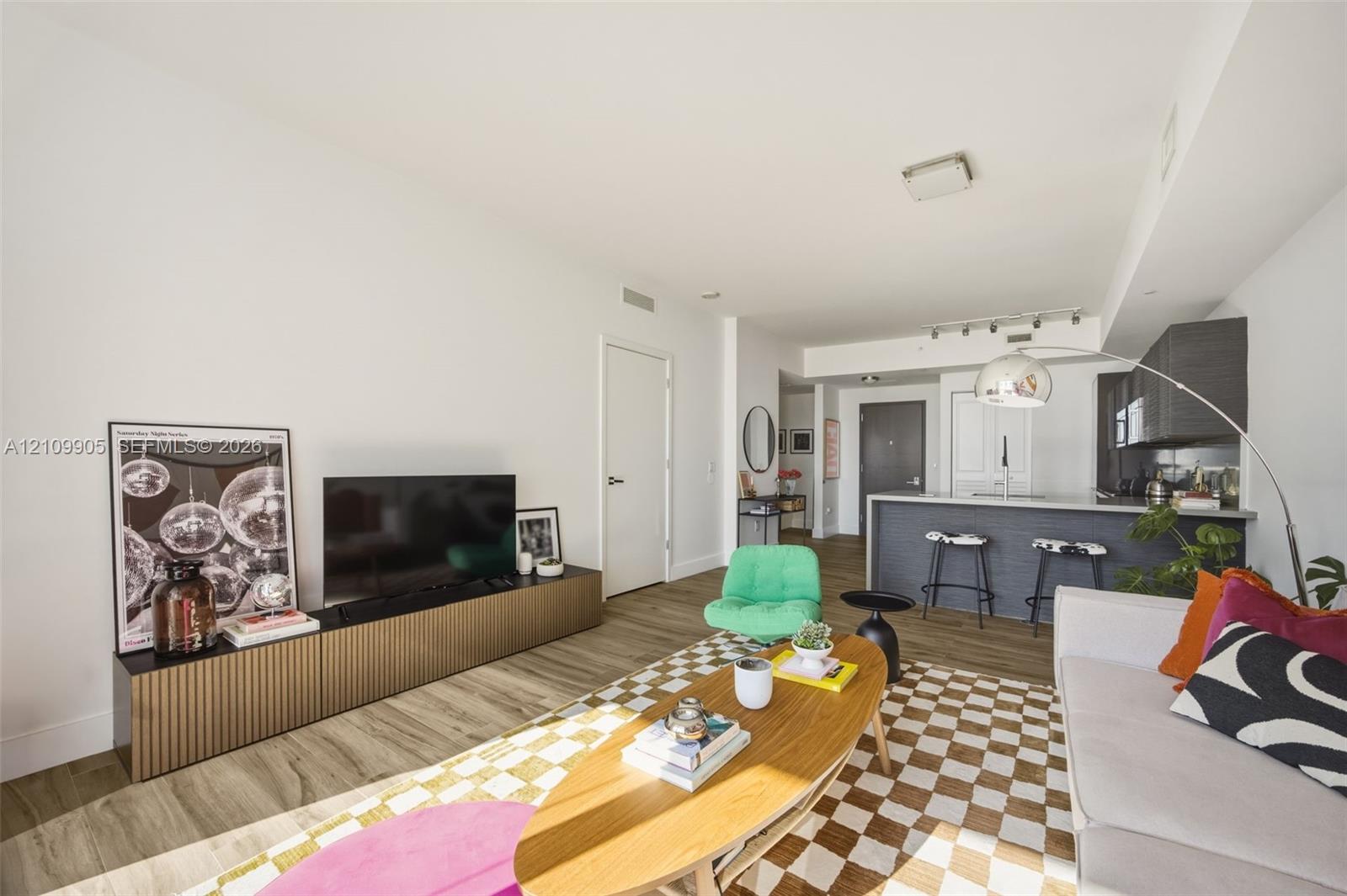Open concept interior featuring wood-finish flooring, recessed lighting, and a kitchen island with stone countertop