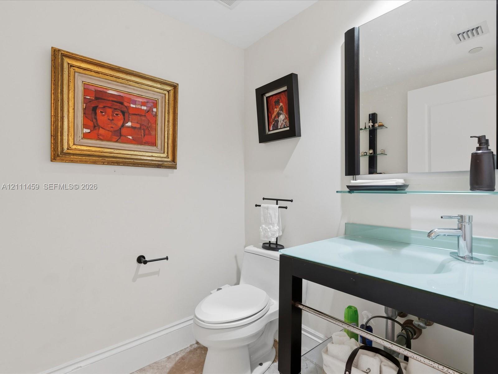Floating vanity featuring a frosted glass countertop with an integrated sink and matte black metal frame, paired with a matching rectangular wall mirror