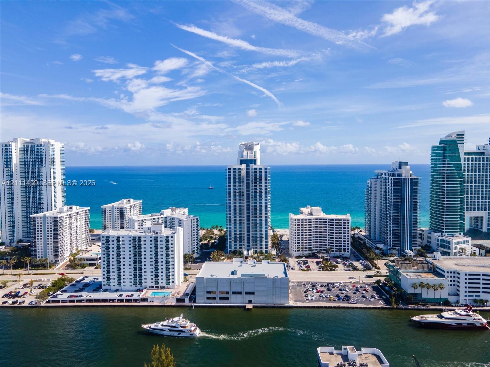 Aerial perspective featuring coastal high-rise architecture, direct water frontage, deep-water access, and horizon ocean scenery