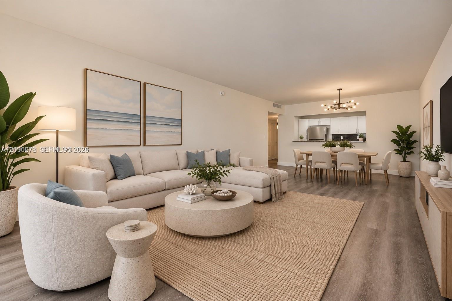 Open concept living area featuring wood-finish flooring, a contemporary multi-arm chandelier, and a pass-through kitchen opening