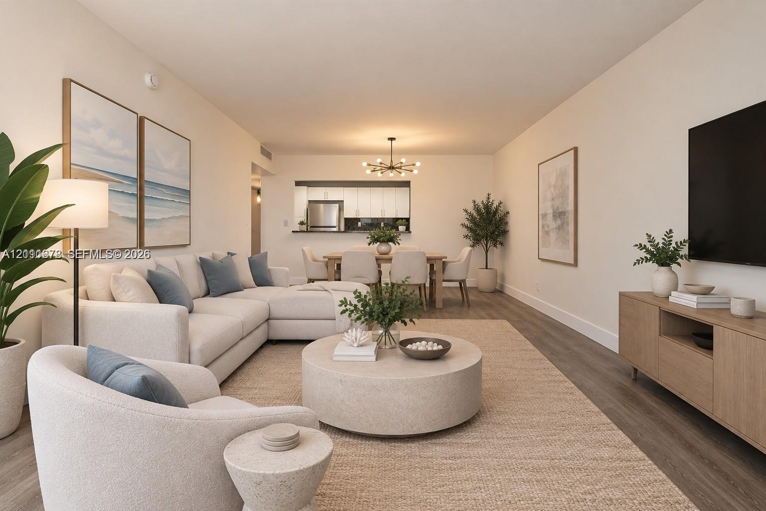 Open-concept living area featuring wood-finish flooring, a contemporary multi-arm chandelier, and a pass-through kitchen opening